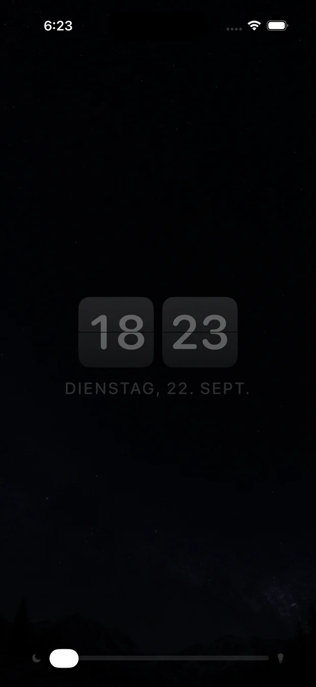 Nachttischmodus: eine dunkle Fallblattuhr vor einem Sternfeld, mit dem
                Nachtlicht‑Schieberegler unten.